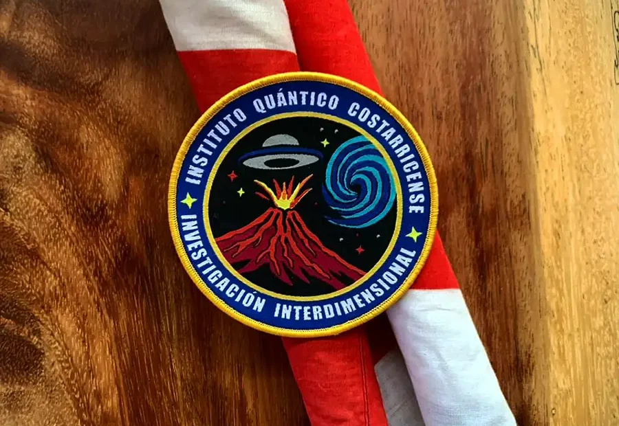 Parche del Instituto Cuantico Costarricense par ala nvestgacon nterdmensonal sobre bandera de Costa Rica