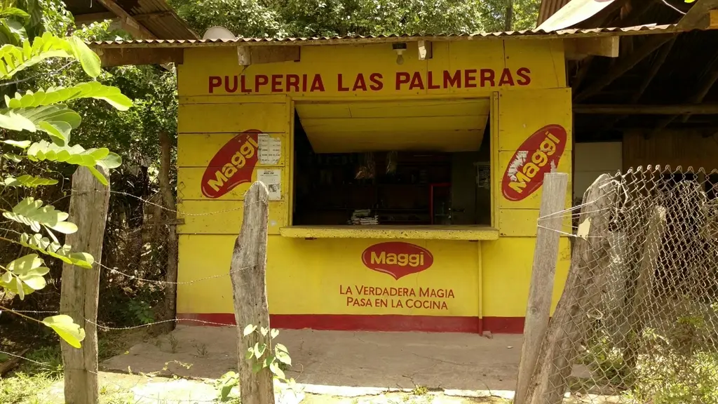 Pulpería rural de madera pintada de amarillo en Garza, Nicoya, con rótulos de Maggi en su fachada.