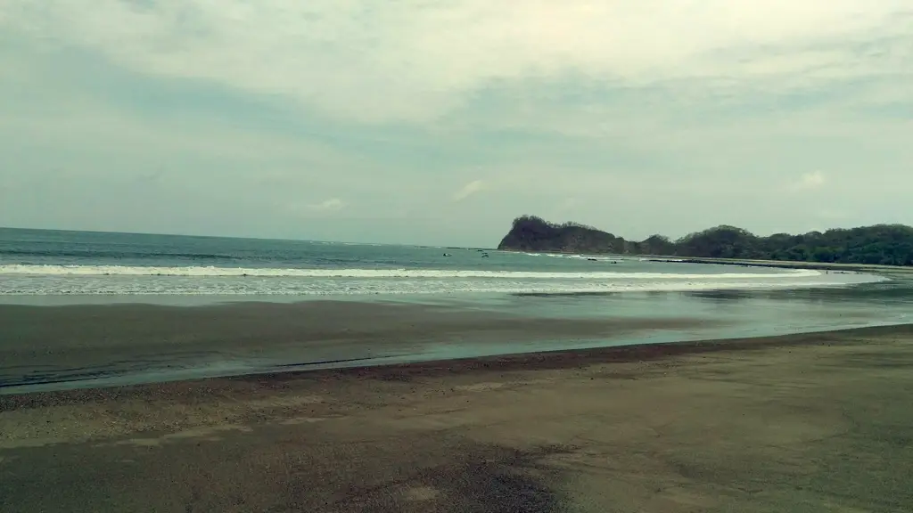 Vista de Playa Garza con la arena oscura y el mar abierto bajo un cielo nublado en la Península de Nicoya.