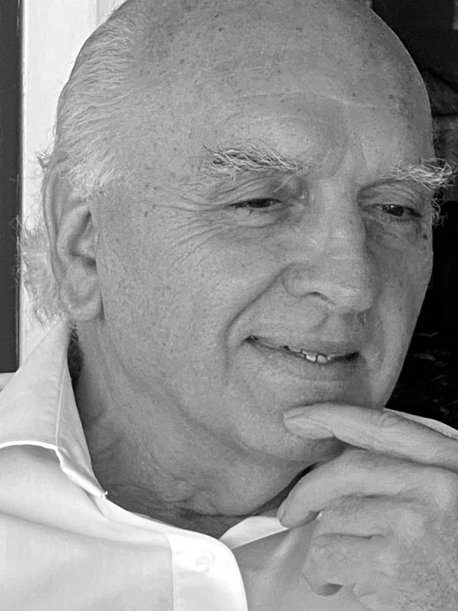 Retrato en blanco y negro de un hombre mayor con expresión pensativa.