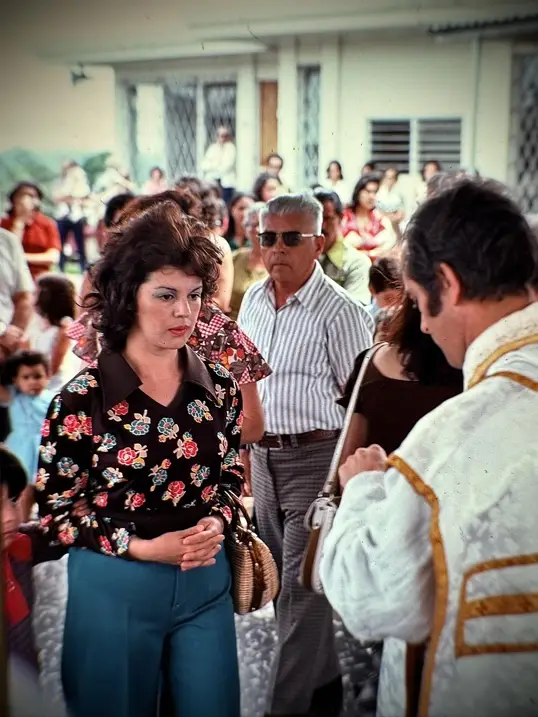 Mujer joven recibiendo la comunión en una misa al aire libre.