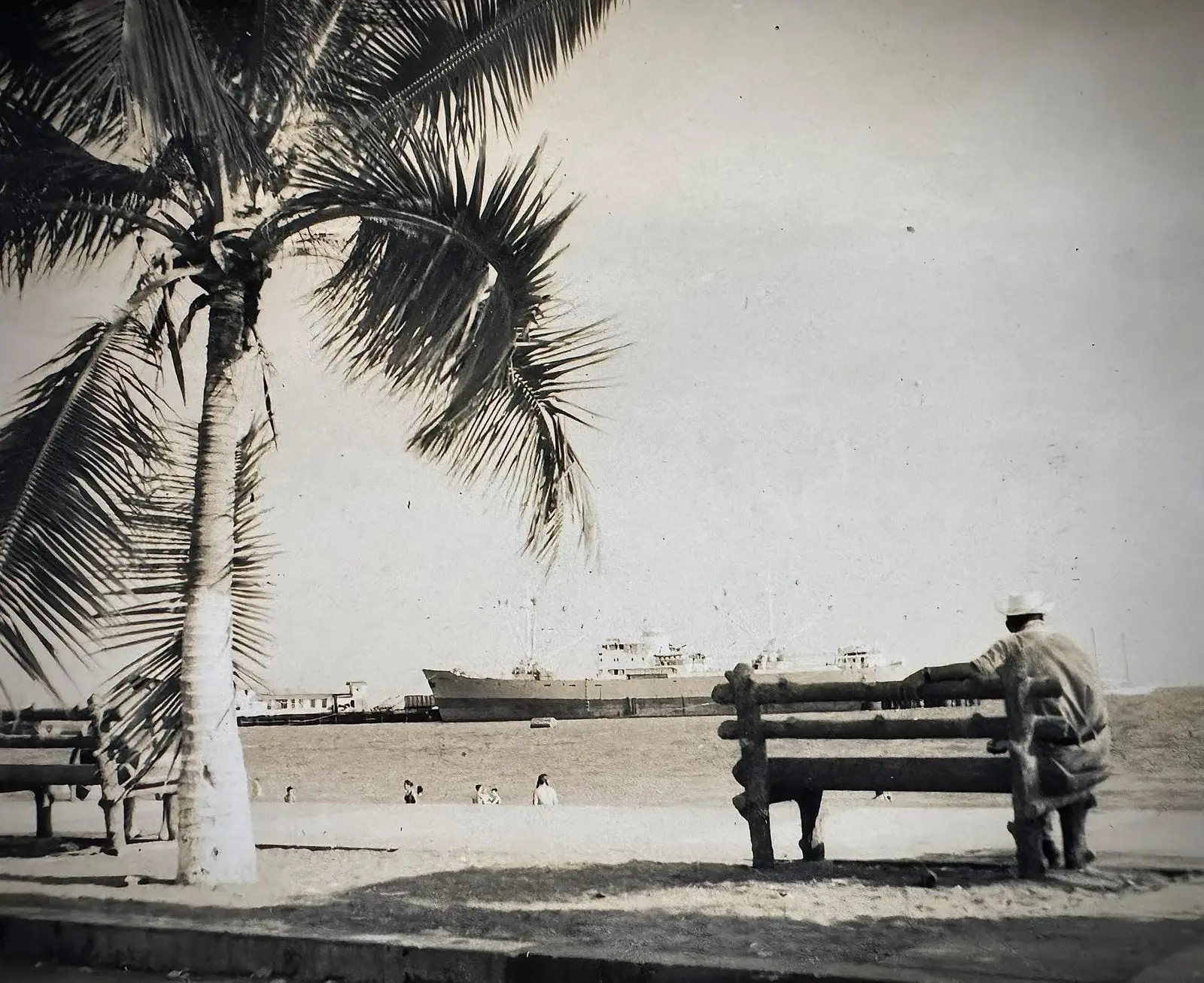 Hombre solitario sentado en una banca frente al mar en Puntarenas.