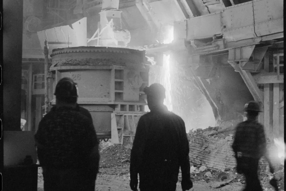 Obreros frente a un horno industrial encendido en plena faena nocturna.