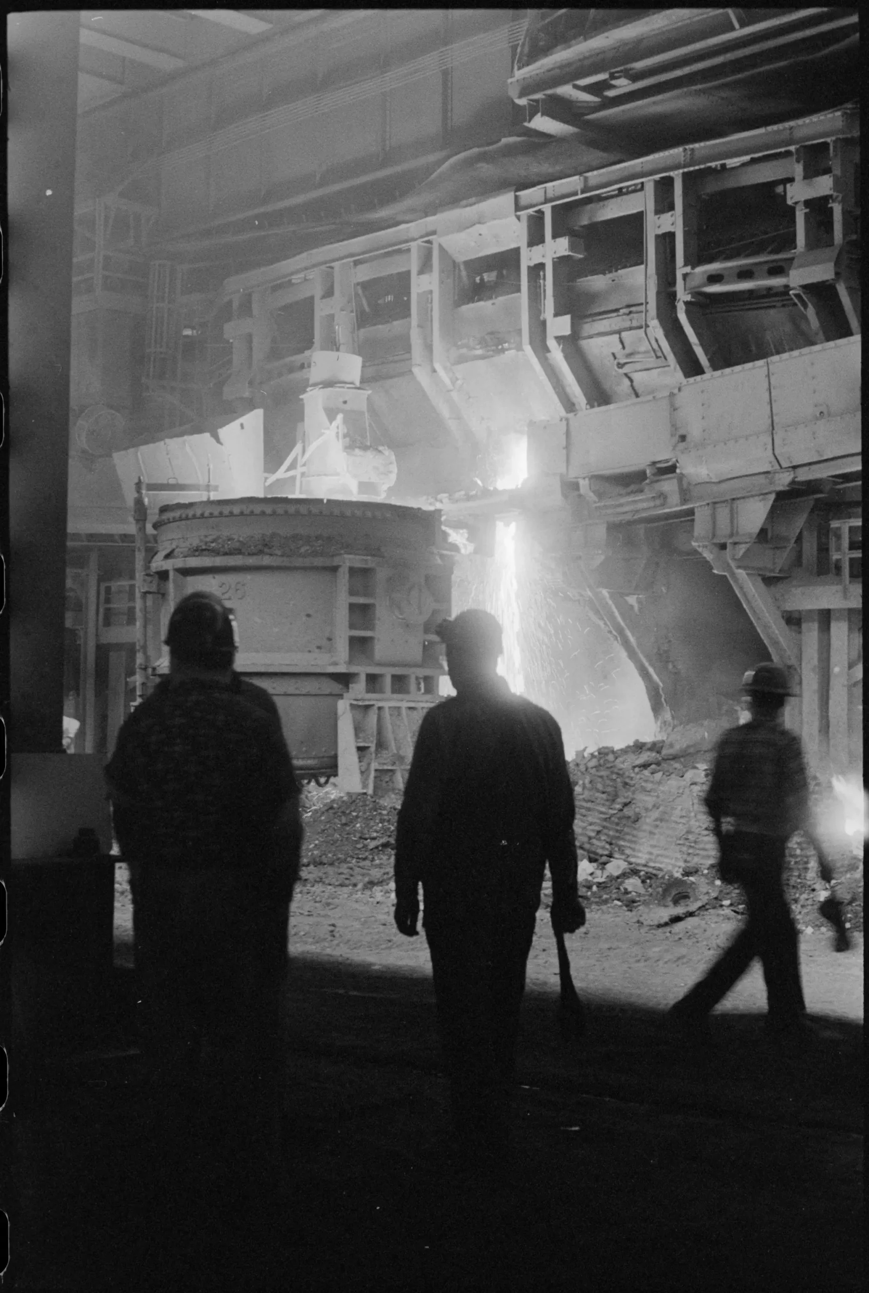 Obreros frente a un horno industrial encendido en plena faena nocturna.