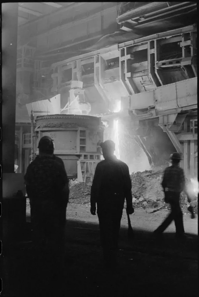 Obreros frente a un horno industrial encendido en plena faena nocturna.