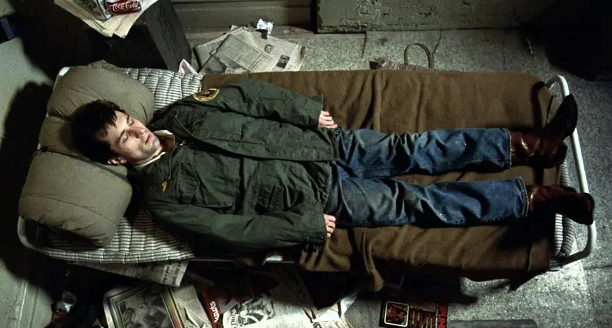 Personaje de cine recostado en cama vistiendo chaqueta M-65.