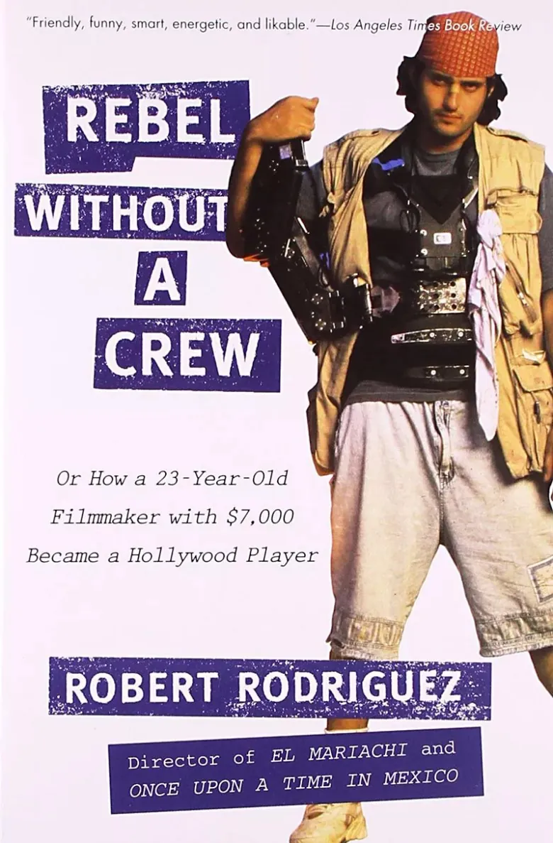 Portada del libro Rebel Without a Crew, de Robert Rodriguez, con el director cargando una cámara y equipo de filmación.