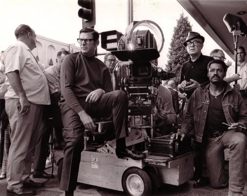 Equipo de rodaje en la calle, con el director sentado sobre el dolly de la cámara.